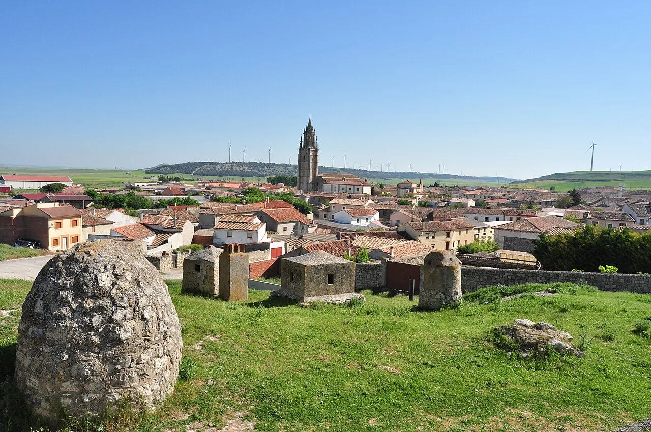 Blick auf Ampudia mit alten Mauern und einer Kirche im Hintergrund.