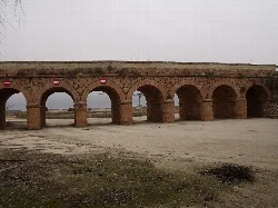 Stone bridge with multiple arches and no-entry signs.