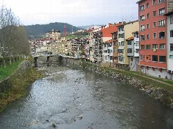Deba-Fluss mit Gebäuden und Brücke in Elgoibar, Guipúzcoa.