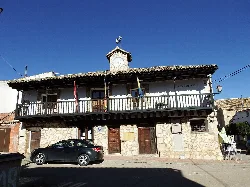 Town hall building with clock and balcony in Olmeda del Rey.