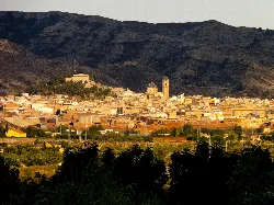 Blick auf Agost, Alicante, mit Kirchen und Häusern im Tal, umgeben von Bergen.