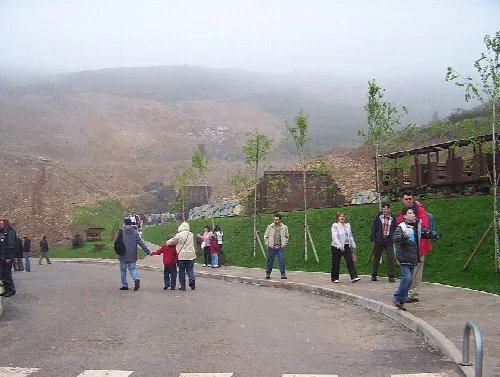 Entrada a la cueva de El Soplao con visitantes y paisaje montañoso.