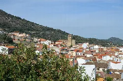 Blick auf weiße Häuser und grüne Hügel in Castillo de Bayuela, Toledo.
