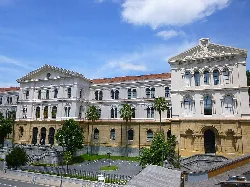Facade of Deusto University in Bilbao with columns and palm trees