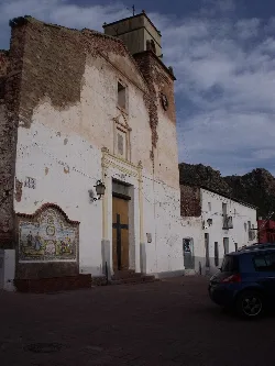 Iglesia con paredes desgastadas y mural en la fachada en Marines.