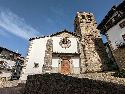 Church with stone tower and white facade in Candelario.