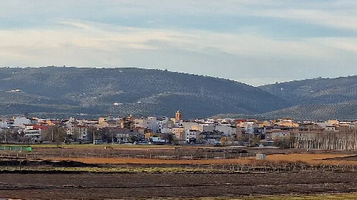 Landschaft mit Stadt und Hügeln im Hintergrund.