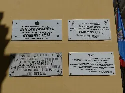 Vier Plaketten an einer Wand mit Texten und Wappen, in San Fernando, Cádiz.