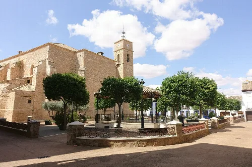 Kirche des Apostels Jakobus und Platz mit Bäumen in Villanueva de Alcardete