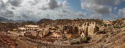 Restos de estructuras mineras en un paisaje árido y montañoso.
