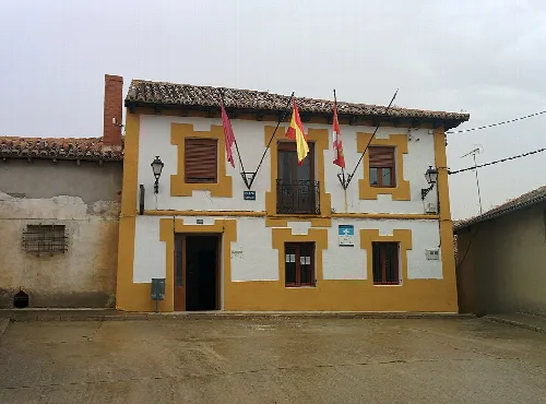 Edificio del ayuntamiento con banderas en la fachada en Urones de Castroponce.