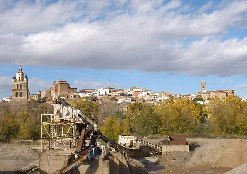 Blick auf Calahorra mit historischen Gebäuden und Bäumen im Vordergrund.
