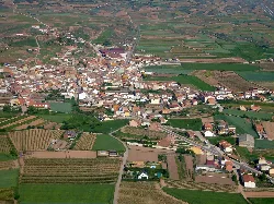 Vista aérea de Huércanos con edificios y campos verdes.