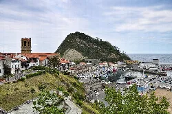 Puerto de Getaria con casas y colina en Guipúzcoa.