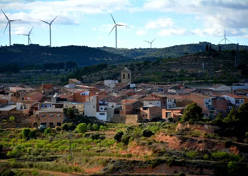 Pueblo en Terra Alta con molinos de viento en el fondo.