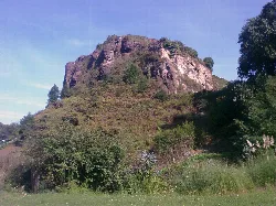 Peñón de Raíces with greenery and blue sky.