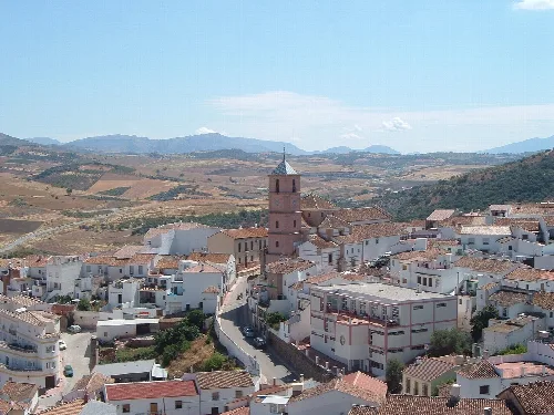 Luftaufnahme von Casabermeja mit Kirche und weißen Häusern im August.