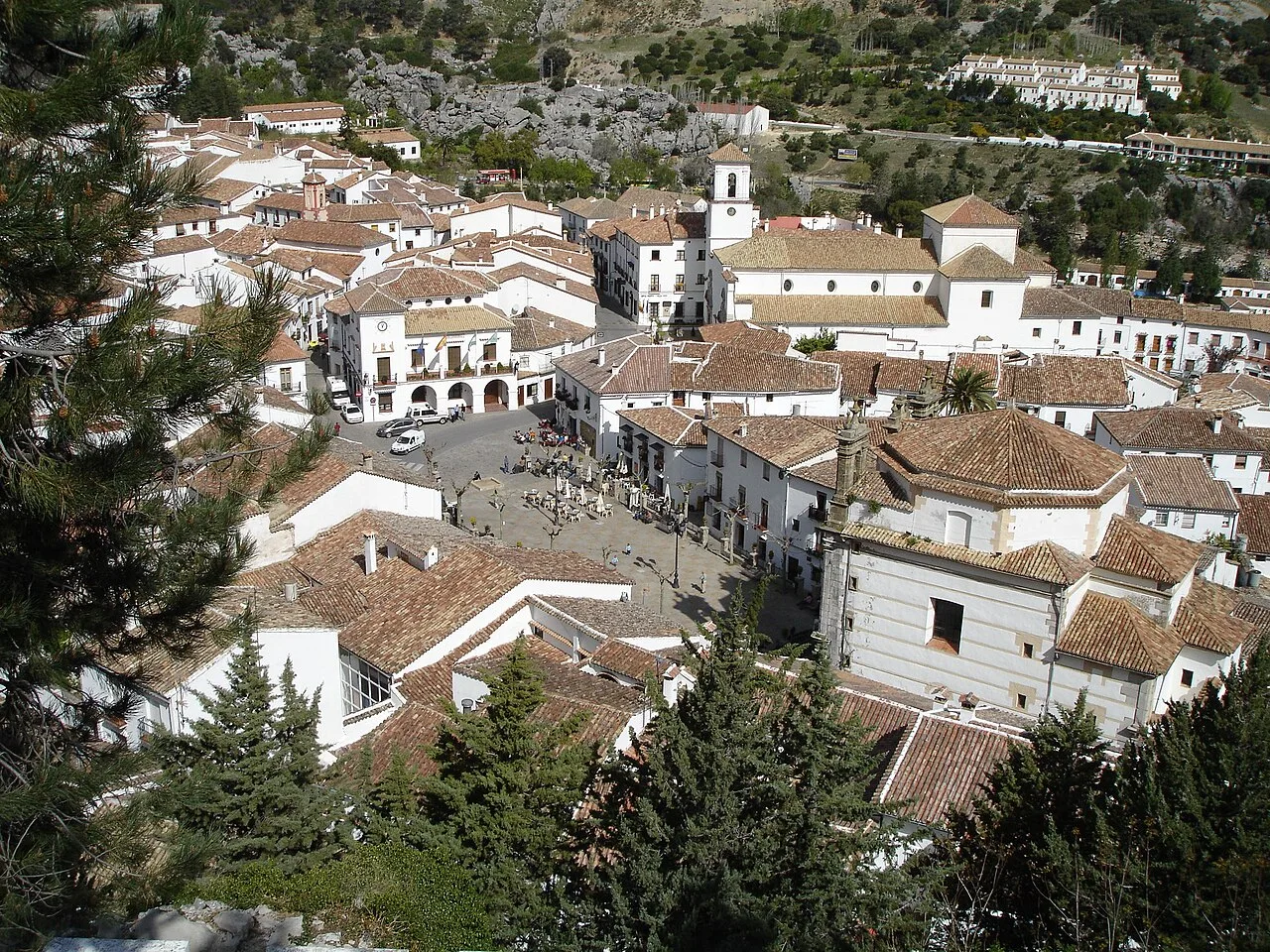 Grazalema town hall square with white buildings and trees.