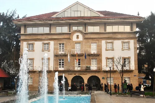 Verín Rathaus mit Brunnen und Menschen auf dem Platz.
