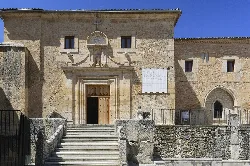 Steinfassade mit Treppe und Holztür in Caleruega.