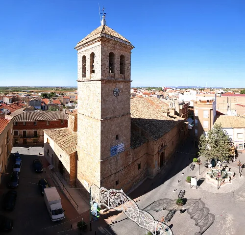 Torre de la iglesia parroquial en Villamalea, con calles y plazas alrededor.