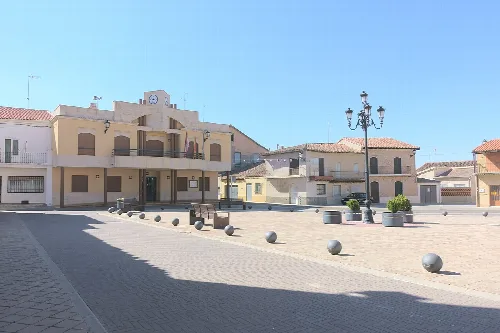 Rathaus von Fuentelapeña in Zamora, mit Straßenlaternen und Bänken im Platz.