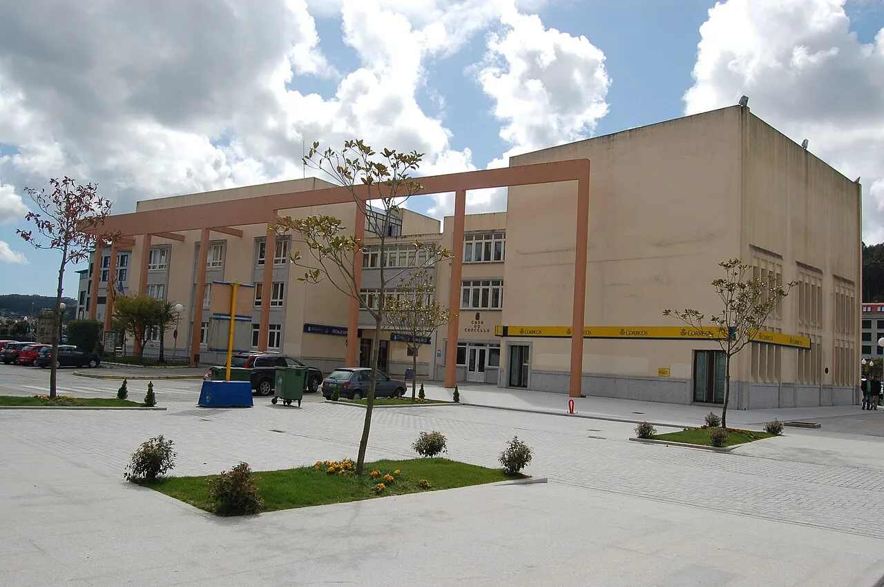 Edificio de la casa consistorial de Cee con un diseño moderno y una plaza en frente