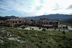 Stone houses in Riópar Viejo with mountains and cloudy sky