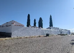Friedhof mit weißer Mauer und vier Zypressen in Mata de Alcántara.