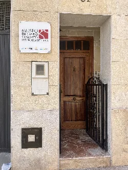 Puerta de entrada con cartel del museo y reja negra en Masamagrell.