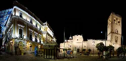 Nachtansicht des Plaza de España in Badajoz mit historischen Gebäuden und Turm.