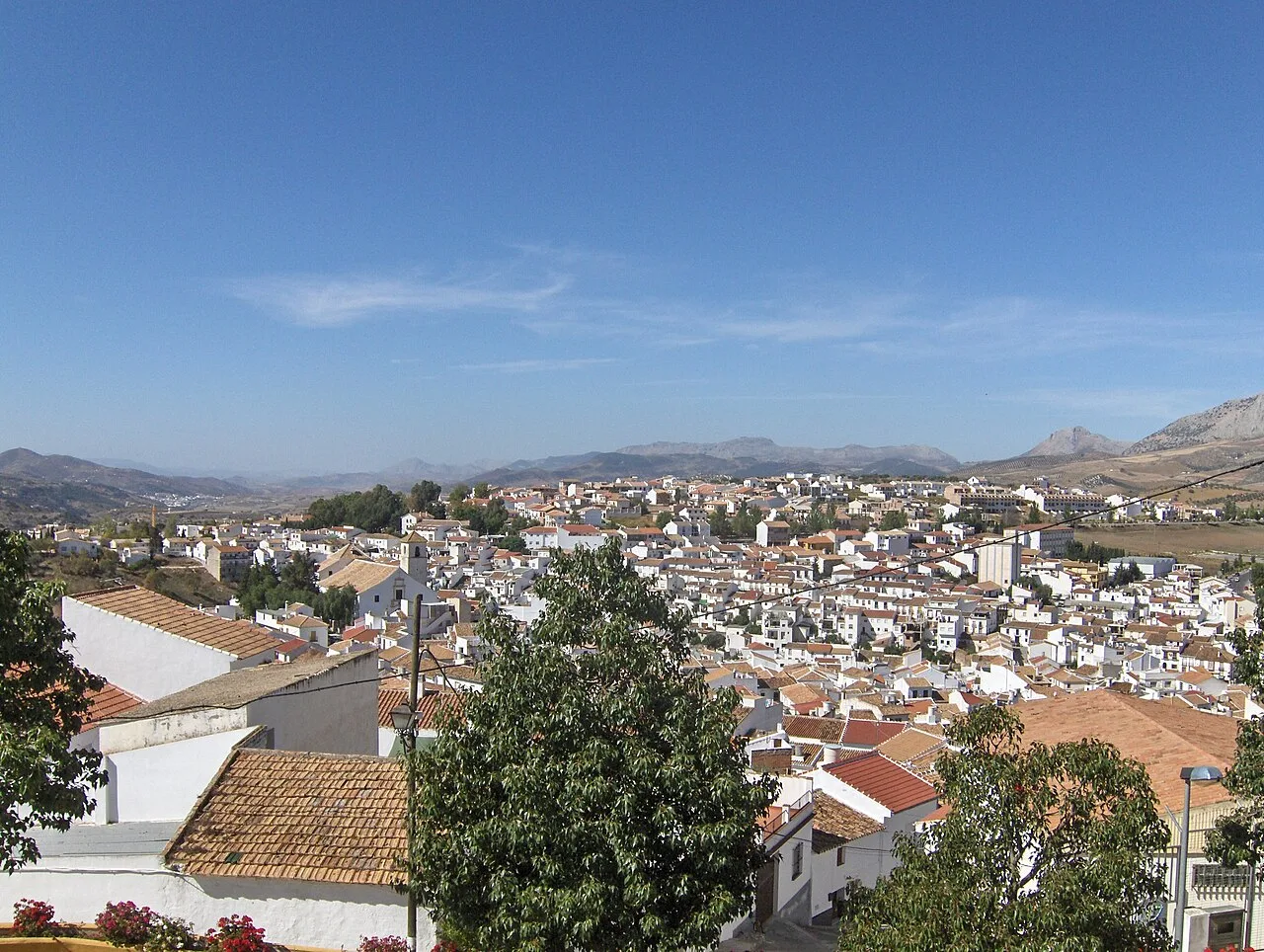 Vista de Colmenar con casas blancas y montañas en el fondo.