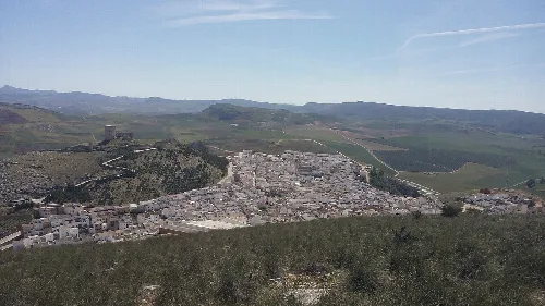 Blick auf Teba mit Gebäuden und Hügeln im Hintergrund.