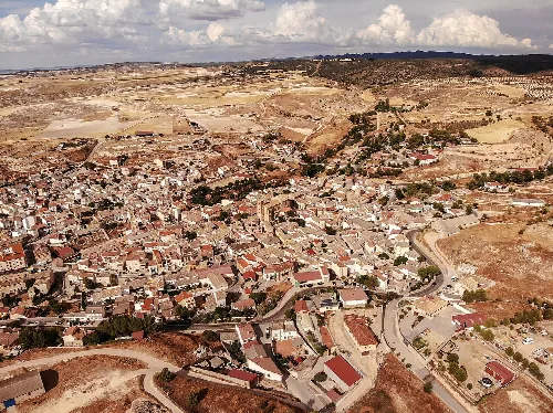 Luftaufnahme von Illana mit Straßen und Gebäuden in einer ländlichen Umgebung.