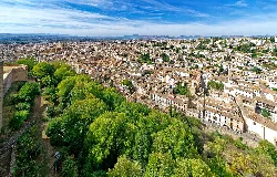 Panoramic view of Granada from the Alhambra with trees and city.