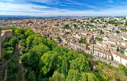 Panoramablick auf Granada von der Alhambra mit Bäumen und Stadt.