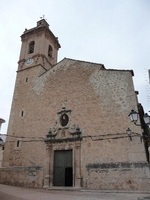 Church with bell tower in Arañuel, Castellón, with baroque details around the entrance.