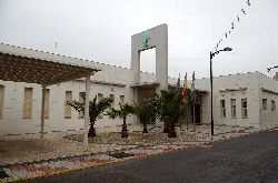 Ambulatorio de Calamonte en Badajoz, España, con palmeras y banderas.