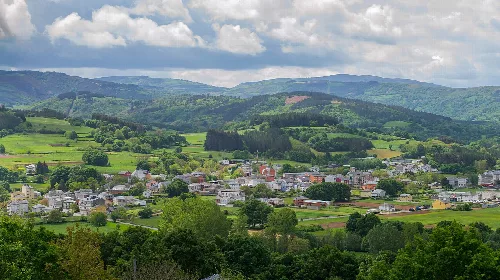 Landschaft mit Häusern, Feldern und grünen Hügeln in Baralla, Lugo.