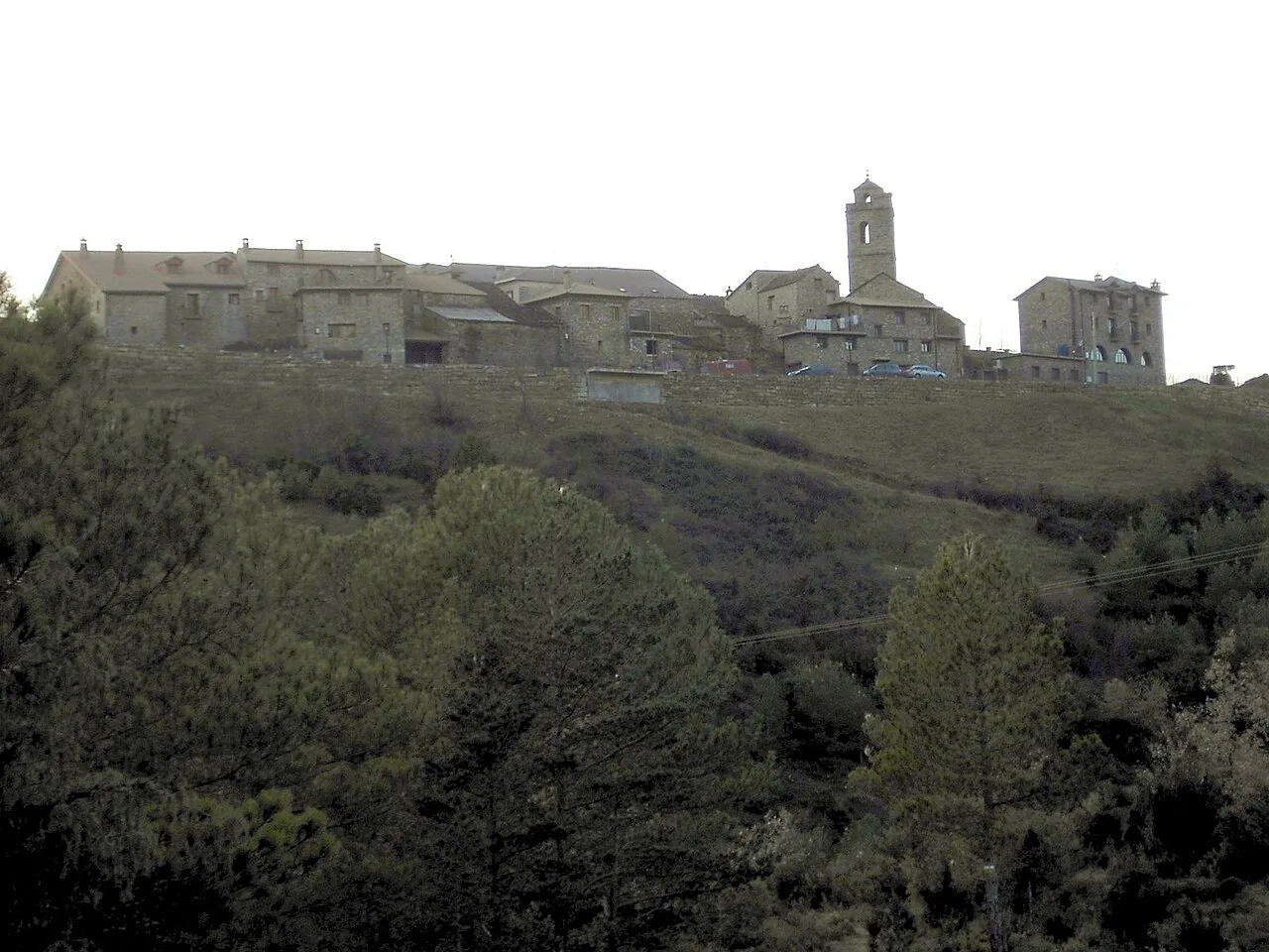 Häuser und eine Kirche auf dem Hügel bei Dämmerung.