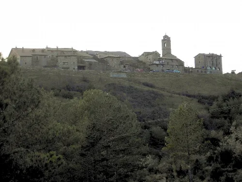 Häuser und eine Kirche auf dem Hügel bei Dämmerung.