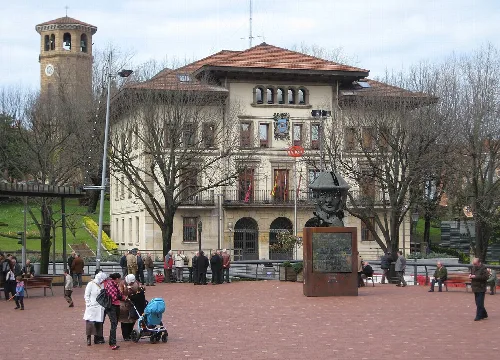 Plaza en Sestao con edificio del ayuntamiento y escultura de busto.