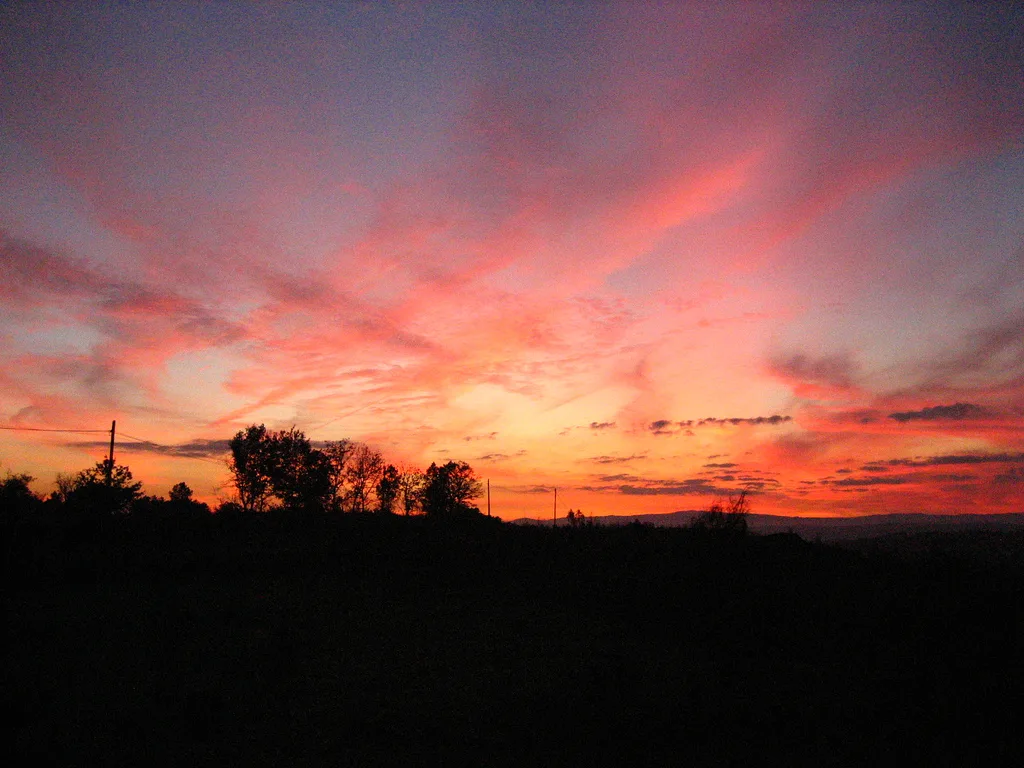 Pink sky and scattered clouds in Amoeiro at sunset.
