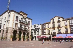 Square with historic buildings and shaded terraces in Torrelavega.