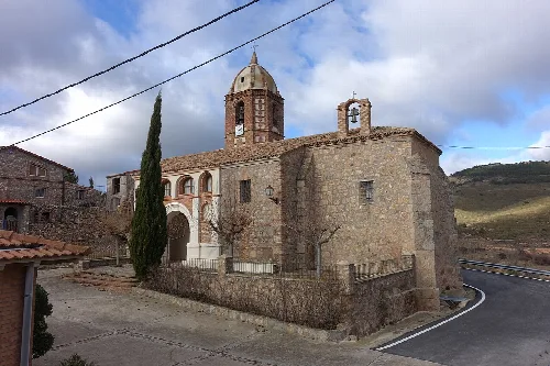 Iglesia de piedra con torre y cúpula en Villarroya.