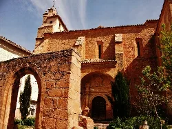 Facade of Our Lady of Milk Church with arch and wooden doors.