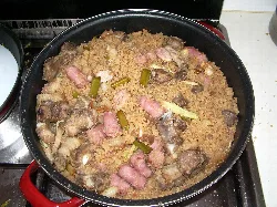 Migas ruleras en una sartén con pan, longaniza, tocino y ajos.