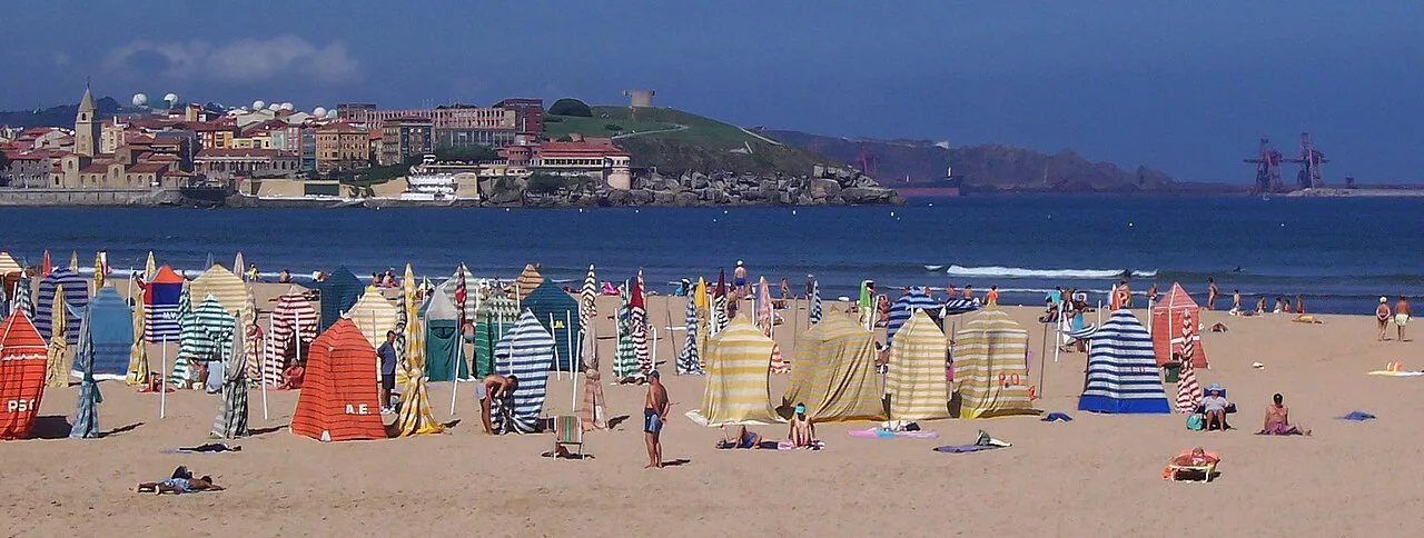 Strand von San Lorenzo mit Sonnenschirmen und Touristen.
