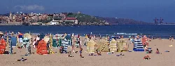 Saint Lawrence Beach with umbrellas and tourists on the sand.