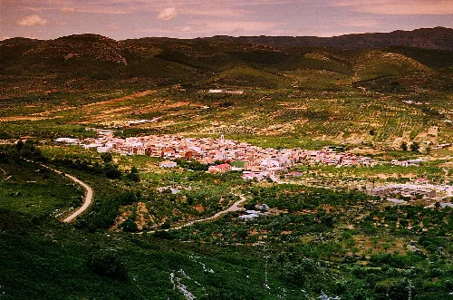 Aerial view of Tirig with mountains and green fields.